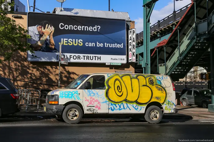 A photo of truck with graffiti on it under a sign for Jesus